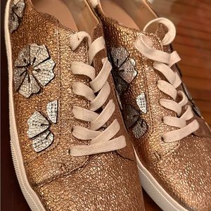 Vince Camuto gold metallic sneakers with silver flower motif overlay